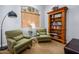 Cozy sitting room with chairs, bookshelf, and a large window with sun filtering blinds at 4465 E Paradise Village S Pkwy # 1179, Phoenix, AZ 85032