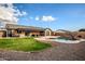 A serene backyard featuring a swimming pool, gravel landscaping, and a covered patio for relaxation and entertainment at 502 N 110Th St, Mesa, AZ 85207