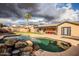 Relaxing backyard with a freeform pool featuring rock accents and a covered patio for entertaining at 502 N 110Th St, Mesa, AZ 85207