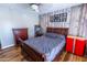 Bedroom featuring wood floors, a ceiling fan, dresser and rustic wood accent wall at 502 N 110Th St, Mesa, AZ 85207