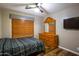 Bedroom featuring wood floors, a ceiling fan, dresser, mirror and flat screen TV at 502 N 110Th St, Mesa, AZ 85207