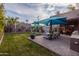 Well-manicured backyard with a blue sunshade, dining area, outdoor kitchen, and lush landscaping at 59 W Cypress St, Phoenix, AZ 85003