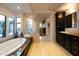 Luxurious bathroom featuring a soaking tub, natural light, glass enclosed shower, and dual vanities at 59 W Cypress St, Phoenix, AZ 85003