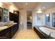 Primary bath features dual sinks, dark wood cabinets, soaking tub, and ensuite bedroom access at 59 W Cypress St, Phoenix, AZ 85003