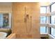 Elegant bathroom featuring a modern shower with travertine tile and natural light from surrounding windows at 59 W Cypress St, Phoenix, AZ 85003