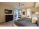 Open bedroom with patio access, mounted TV, ceiling fan, and ensuite bath in a luxurious home at 59 W Cypress St, Phoenix, AZ 85003