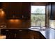 A stainless steel sink sits beneath a window in this kitchen with dark wood cabinetry at 59 W Cypress St, Phoenix, AZ 85003