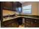 Laundry room features a utility sink, dark cabinets, and granite countertops at 59 W Cypress St, Phoenix, AZ 85003