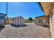 Gravel backyard featuring a shed, RV, hot tub, and access to the house with an AC unit at 6319 E Duncan St, Mesa, AZ 85205