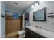 Bright bathroom with a shower, vanity with dark wood cabinets, and modern mirror at 6319 E Duncan St, Mesa, AZ 85205