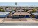 Charming single-story brick home with an American flag, a blue garage door, and desert landscaping at 6319 E Duncan St, Mesa, AZ 85205