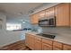 Well-lit kitchen featuring wood cabinets, modern microwave, and smooth cooktop at 6319 E Duncan St, Mesa, AZ 85205
