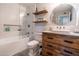 Modern bathroom with stylish tile work, rustic wood cabinets, and floating shelves adds character at 8519 E Rancho Vista Dr, Scottsdale, AZ 85251