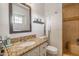 Bathroom featuring a granite countertop, decorative mirror, and tiled shower, creating a stylish space at 8519 E Rancho Vista Dr, Scottsdale, AZ 85251