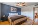 Main bedroom with a blue accent wall, hardwood floors, a ceiling fan, and a large bed at 8519 E Rancho Vista Dr, Scottsdale, AZ 85251