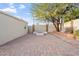 Charming backyard patio with brick pavers, a built-in seating area, mature shade tree, and block wall for privacy at 9245 S 4Th Ave, Phoenix, AZ 85041