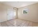 Bright bedroom features tile flooring, window for natural light, and door at 9245 S 4Th Ave, Phoenix, AZ 85041