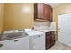 Laundry room with washer, dryer, cabinet storage, utility sink, and door at 9245 S 4Th Ave, Phoenix, AZ 85041
