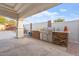 Outdoor kitchen with stainless steel BBQ grill, stone accents, and a covered patio, ideal for backyard entertaining at 9245 S 4Th Ave, Phoenix, AZ 85041