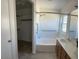 Bathroom featuring a tub and shower, a vanity with dual sinks and a walk-in closet at 9318 E El Paso St, Mesa, AZ 85207