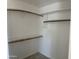 Walk-in closet with white shelving and wood closet rods for optimal storage at 9318 E El Paso St, Mesa, AZ 85207