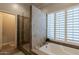 Bathroom with a glass enclosed shower, soaking tub, and windows with shutters, providing both style and privacy at 10431 N 55Th Pl, Paradise Valley, AZ 85253