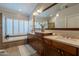 Inviting main bathroom featuring dual sinks, dark wood cabinetry, bright countertops, and a soaking tub at 10431 N 55Th Pl, Paradise Valley, AZ 85253