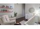 Charming Bedroom features a cozy chair, crib, changing table, and colorful bookshelves with a decorative mirror at 10431 N 55Th Pl, Paradise Valley, AZ 85253