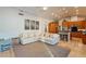 Open-concept living room with a large sectional sofa, connecting to a kitchen with granite countertops and wood cabinets at 10431 N 55Th Pl, Paradise Valley, AZ 85253