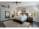 Relaxing main bedroom boasts a tray ceiling, a dark wood bed frame, and ensuite bathroom, for a relaxing space at 10431 N 55Th Pl, Paradise Valley, AZ 85253