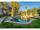 Beautiful backyard oasis featuring a custom-designed pool with rock features, lush landscaping, and green grass at 10431 N 55Th Pl, Paradise Valley, AZ 85253
