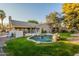 Lush backyard showcasing a custom pool with rock accents, complemented by a well-maintained lawn and landscaping at 10431 N 55Th Pl, Paradise Valley, AZ 85253