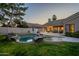 Beautiful backyard pool with rock features surrounded by lush green grass, creating a private retreat at 10431 N 55Th Pl, Paradise Valley, AZ 85253
