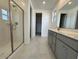 Bathroom with double sinks, walk-in shower, and neutral tile flooring at 15773 W Hackamore Dr, Surprise, AZ 85387