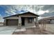 Charming single-story home featuring a covered front porch with stone accents and a two car garage at 15773 W Hackamore Dr, Surprise, AZ 85387