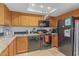 Efficient kitchen featuring wooden cabinets, black appliances, granite counters and warm pendant lighting at 16402 N 31St St # 228, Phoenix, AZ 85032