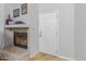 Bright living room with a white door and a cozy fireplace featuring a stone facade and a decorative mantel at 16402 N 31St St # 228, Phoenix, AZ 85032