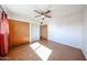 Bedroom featuring ceiling fan, large window, and closet storage at 1757 W Argon St, Mesa, AZ 85201