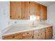 Classic kitchen with a white countertop, wooden cabinets, and essential fixtures at 1757 W Argon St, Mesa, AZ 85201