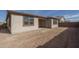 Backyard exterior features neutral siding, brown window trim, and a dirt ground at 17793 W Southgate Ave, Goodyear, AZ 85338