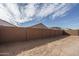 Spacious backyard features a tall brick wall, a dirt ground, and a clear sky at 17793 W Southgate Ave, Goodyear, AZ 85338