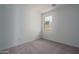 Bright bedroom features neutral carpet, white walls, and a large window at 17793 W Southgate Ave, Goodyear, AZ 85338