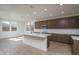 Bright, open kitchen boasts a large white island, modern appliances, and sleek wood-toned cabinetry at 17793 W Southgate Ave, Goodyear, AZ 85338