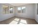 Light-filled living room features neutral walls, tile floors and a large window overlooking the front yard at 17793 W Southgate Ave, Goodyear, AZ 85338