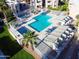 Aerial view of a community pool featuring lounge seating, desert landscaping, and a jacuzzi at 1920 W Lindner Ave # 249, Mesa, AZ 85202