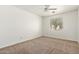 Spacious carpeted bedroom with neutral walls, ceiling fan and a window allowing for natural light at 20329 E Bronco Dr, Queen Creek, AZ 85142