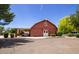 Red building with a barn design with shade and parking at 20329 E Bronco Dr, Queen Creek, AZ 85142