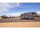 View of RV parking area with multiple RVs lined up on dirt lot under blue skies at 20329 E Bronco Dr, Queen Creek, AZ 85142