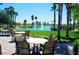 Relaxing outdoor seating area with tables overlooking a tranquil lake and fountain in a well-maintained community space at 2758 N 170Th Ave, Goodyear, AZ 85395