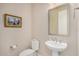 Charming powder room features a pedestal sink, toilet and decorative wall art for a sophisticated, comfortable experience at 2758 N 170Th Ave, Goodyear, AZ 85395